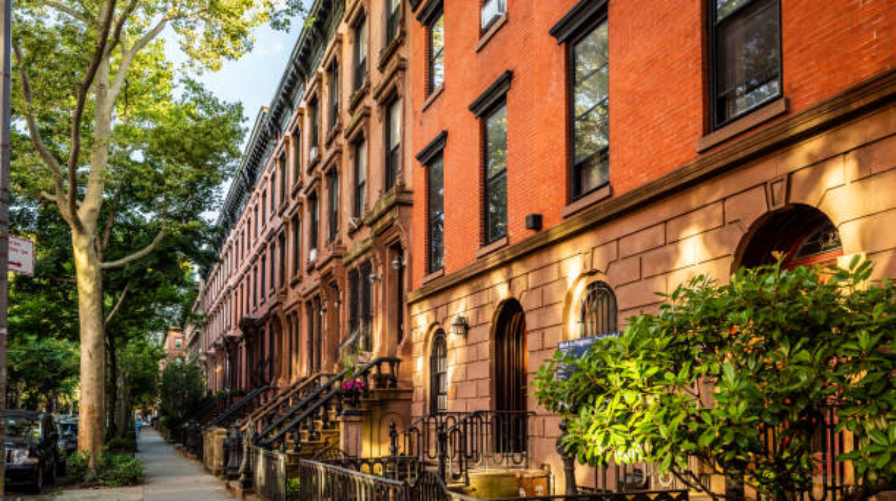 Clinton Hill, Brooklyn, United States - June 30, 2019: Scenic view of a classic Brooklyn brownstone block with a long facade and ornate stoop balustrades on a summer day in Clinton Hills, Brooklyn