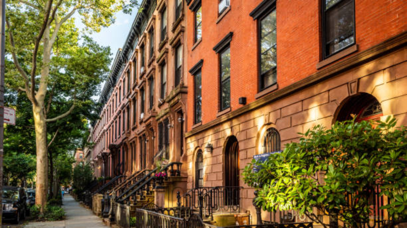 Clinton Hill, Brooklyn, United States - June 30, 2019: Scenic view of a classic Brooklyn brownstone block with a long facade and ornate stoop balustrades on a summer day in Clinton Hills, Brooklyn