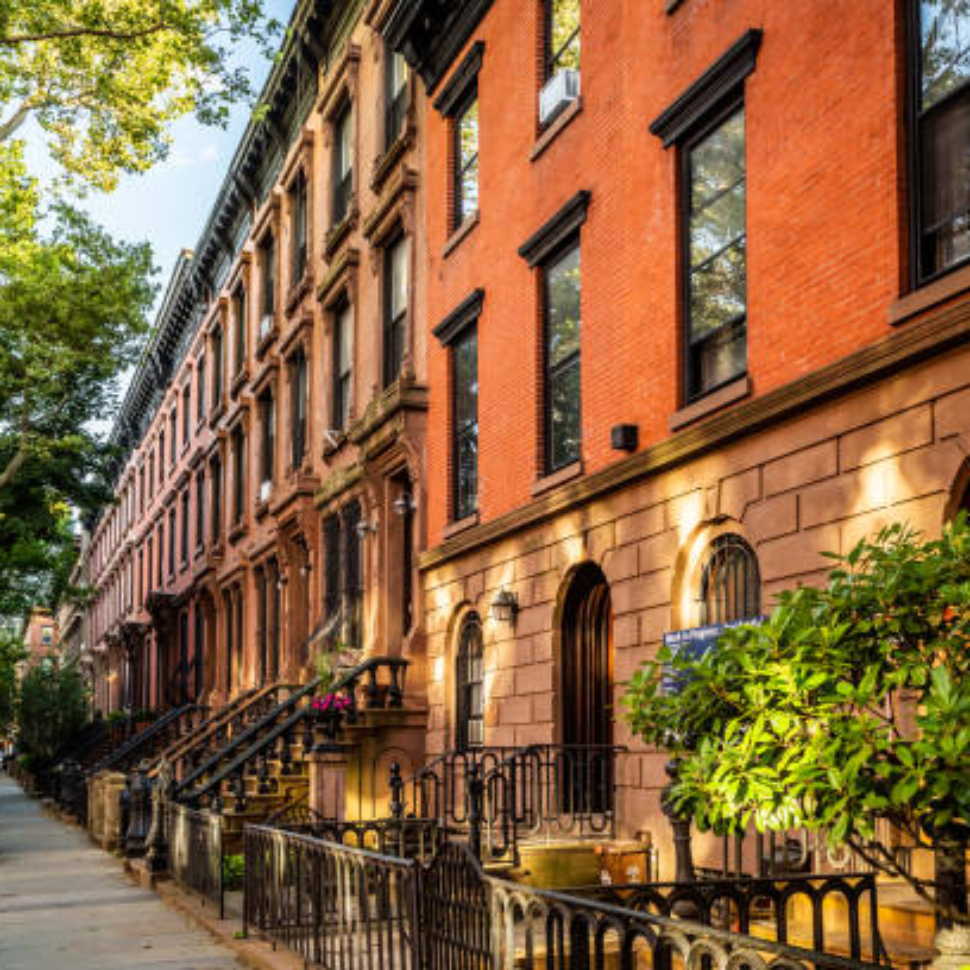 Clinton Hill, Brooklyn, United States - June 30, 2019: Scenic view of a classic Brooklyn brownstone block with a long facade and ornate stoop balustrades on a summer day in Clinton Hills, Brooklyn